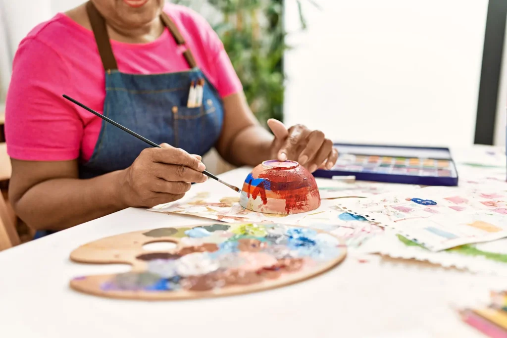 senior woman painting bowl